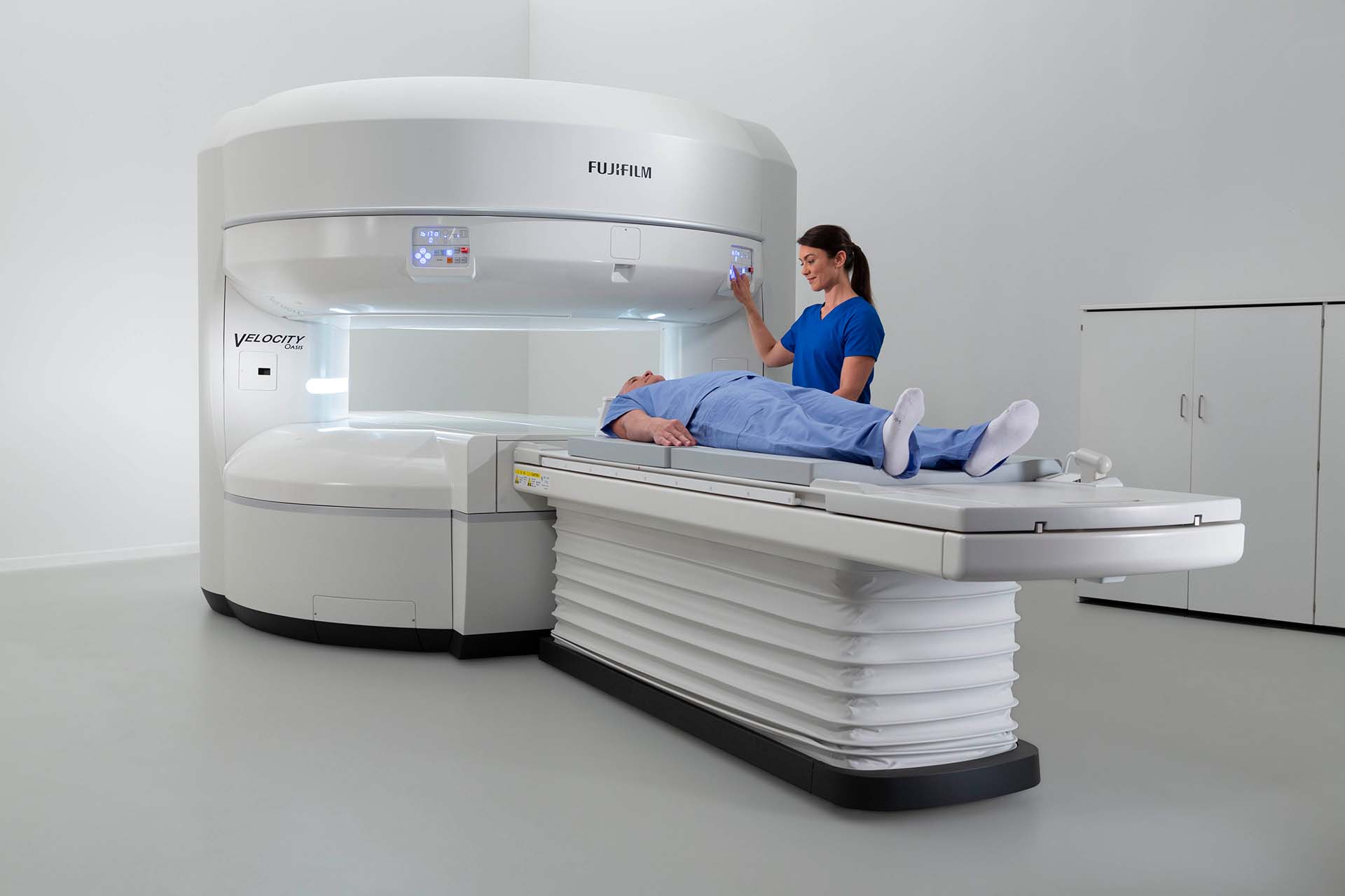 MRI technician guiding patient into open MRI machine MRI technician guiding patient into open MRI machine