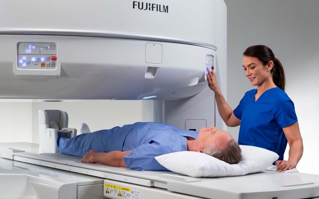 MRI technician guiding patient into open MRI machine