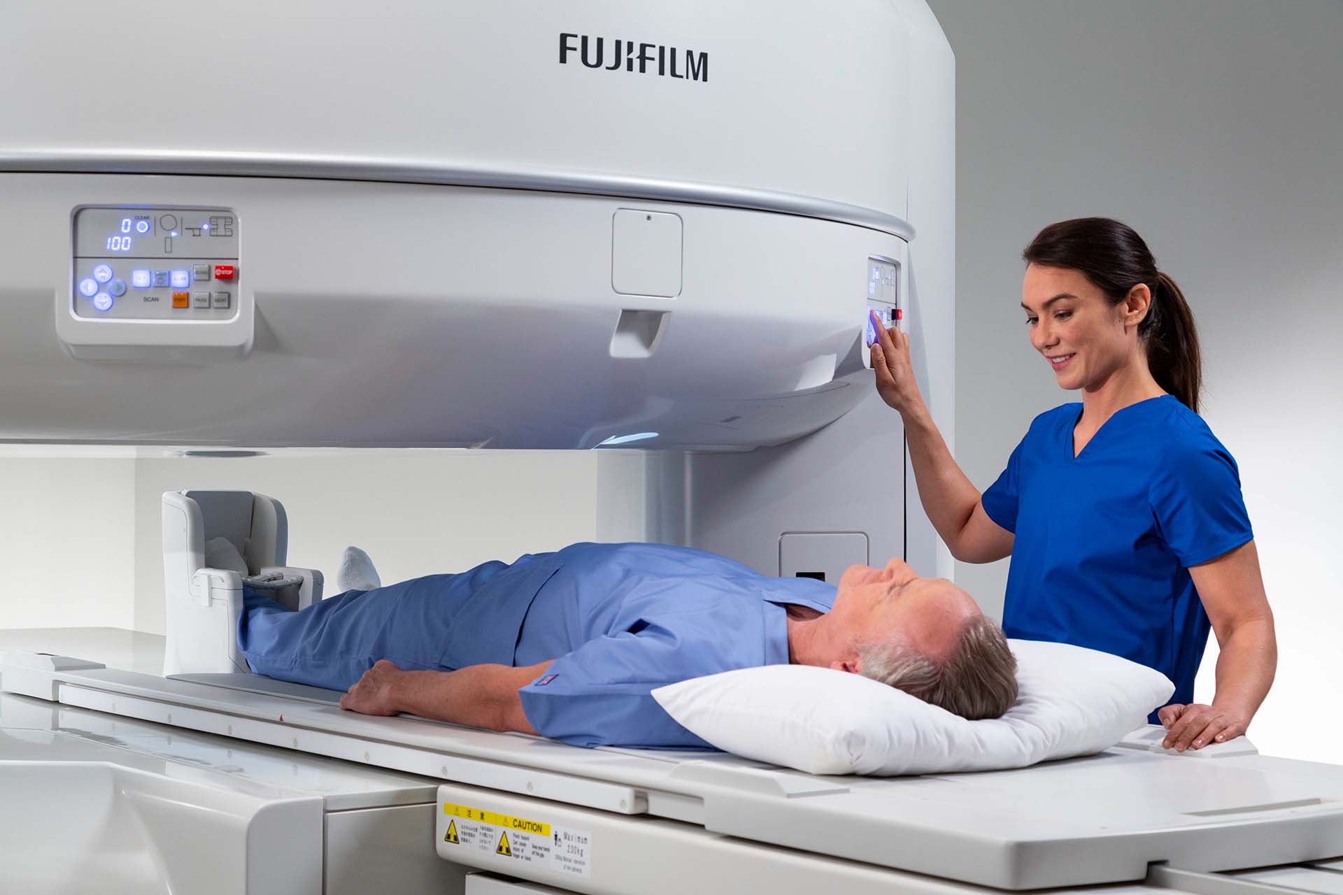 MRI technician guiding patient into open MRI machine MRI technician guiding patient into open MRI machine