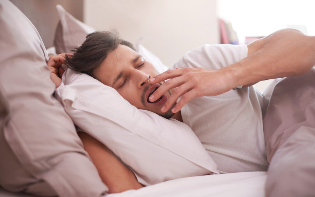 tired man yawning in bed